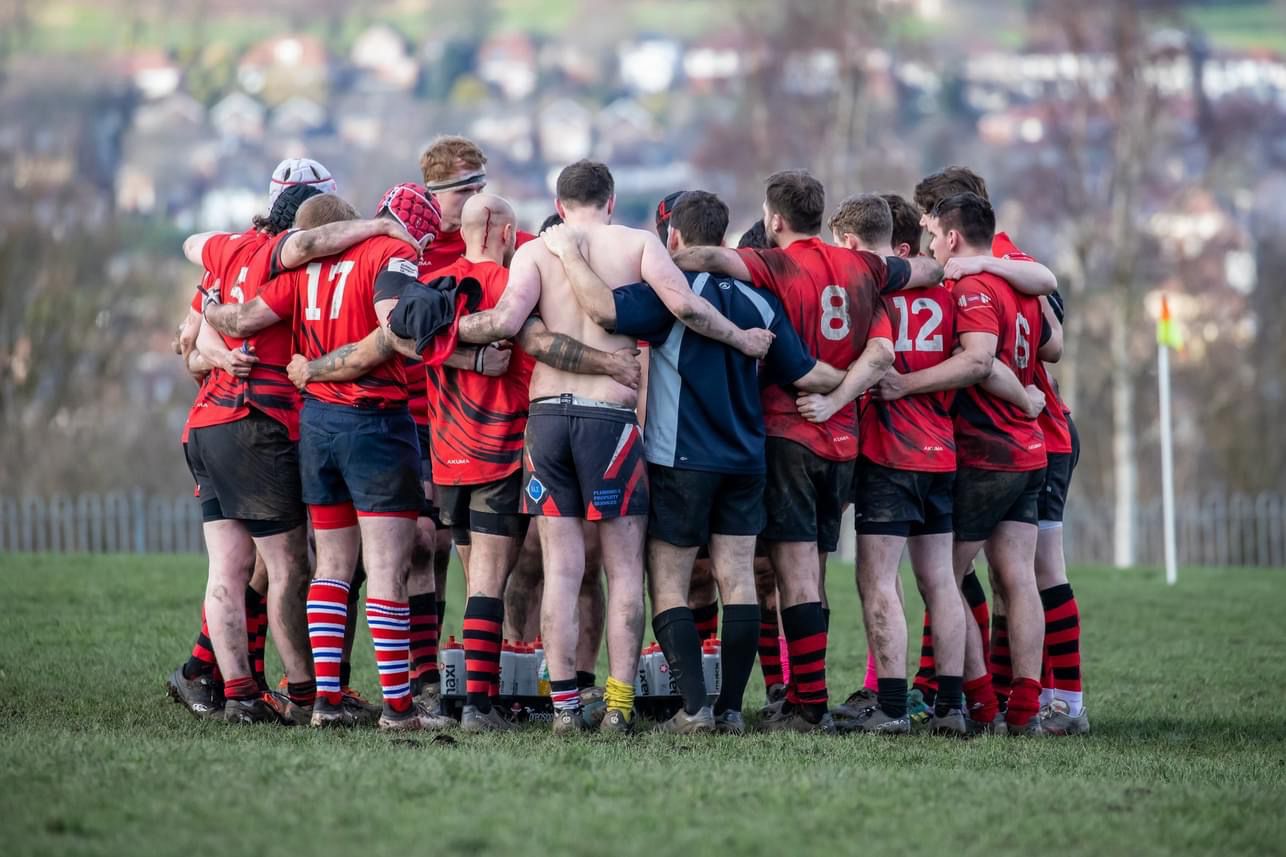 Hallamshire RUFC players stood in a huddle during a break in a game.