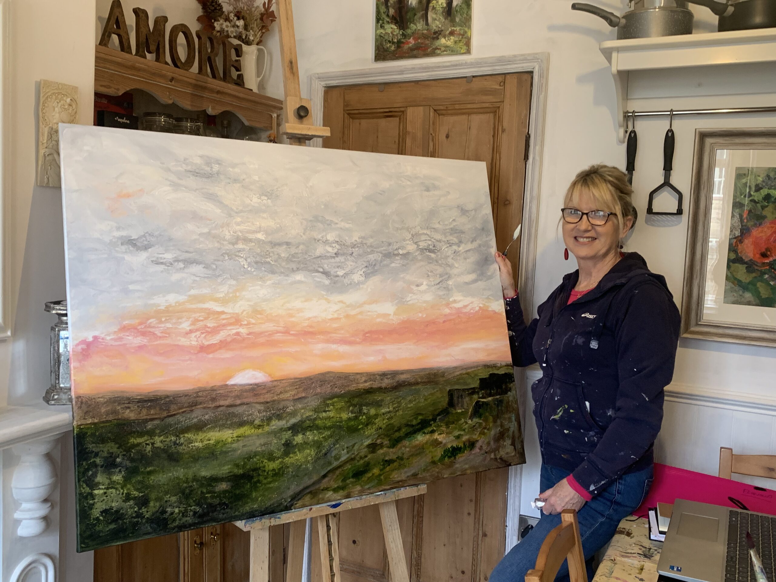 Celia by her latest acrylic piece of Stanage Edge in the