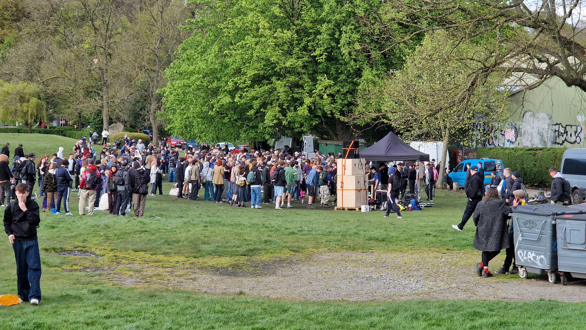 A crowd of people gathered in front of speakers at Endcliffe Park