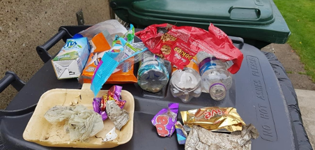 Multiple wrappers of chocolates, sweets and bottles