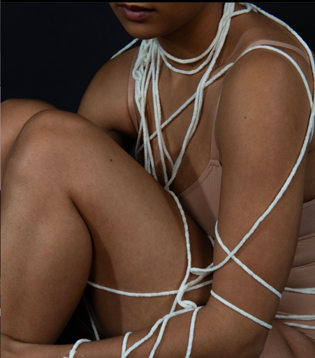 A professional photo of a woman wrapped in string to show her being suffocated by BDD