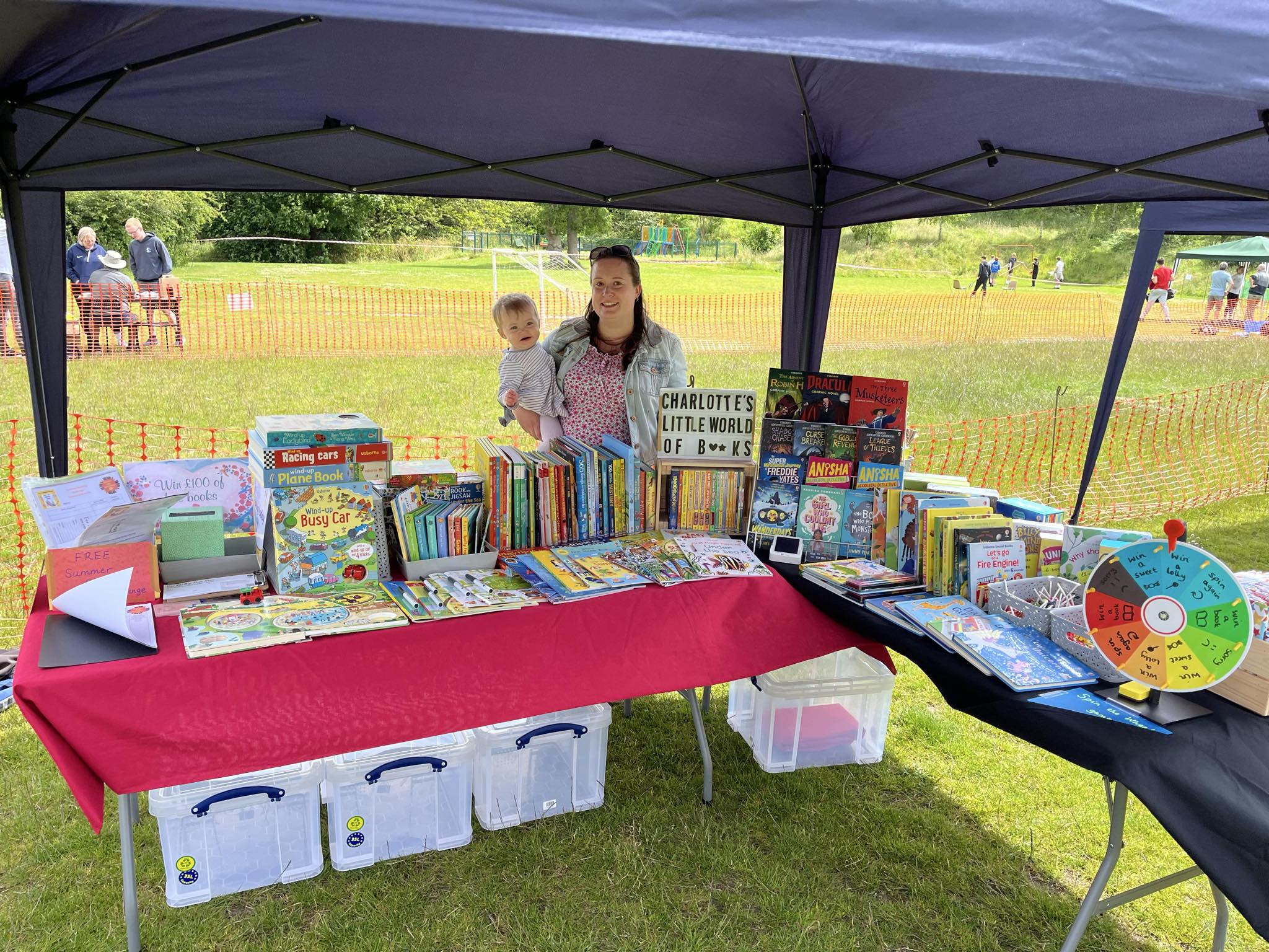 Charlotte Jenkins and her daughter posing behind a table filled with books.