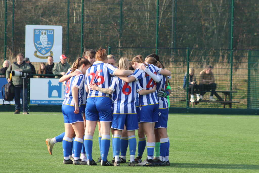 Sheffield Wednesday stand in a team huddle together 