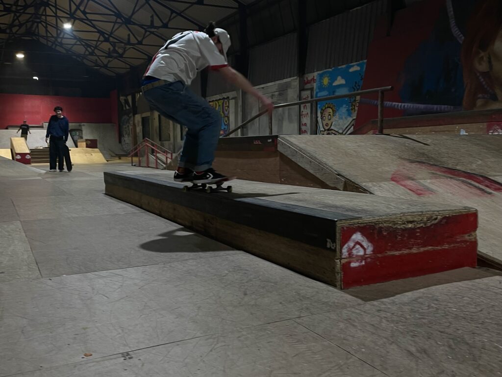 Skateboarder, Dom performing a front 50-50 grind on a ledge during the House Skatepark jam.