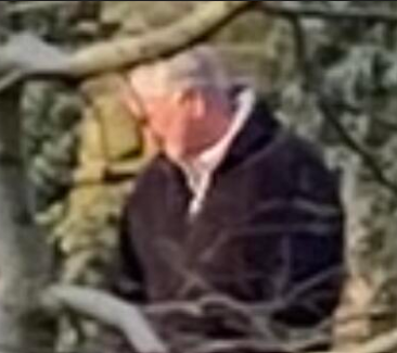 CCTV image of a man with white hair in a dark jacket
