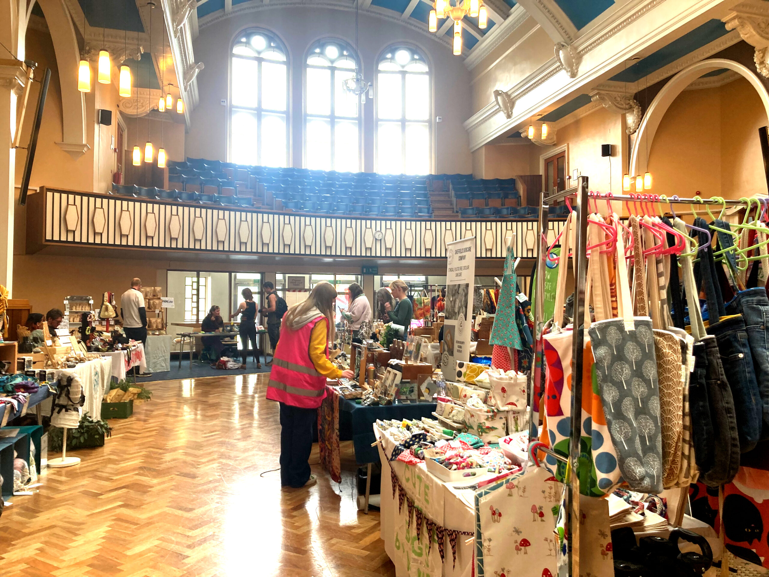 Stalls selling gifts and food in a hall with a window letting in light behind