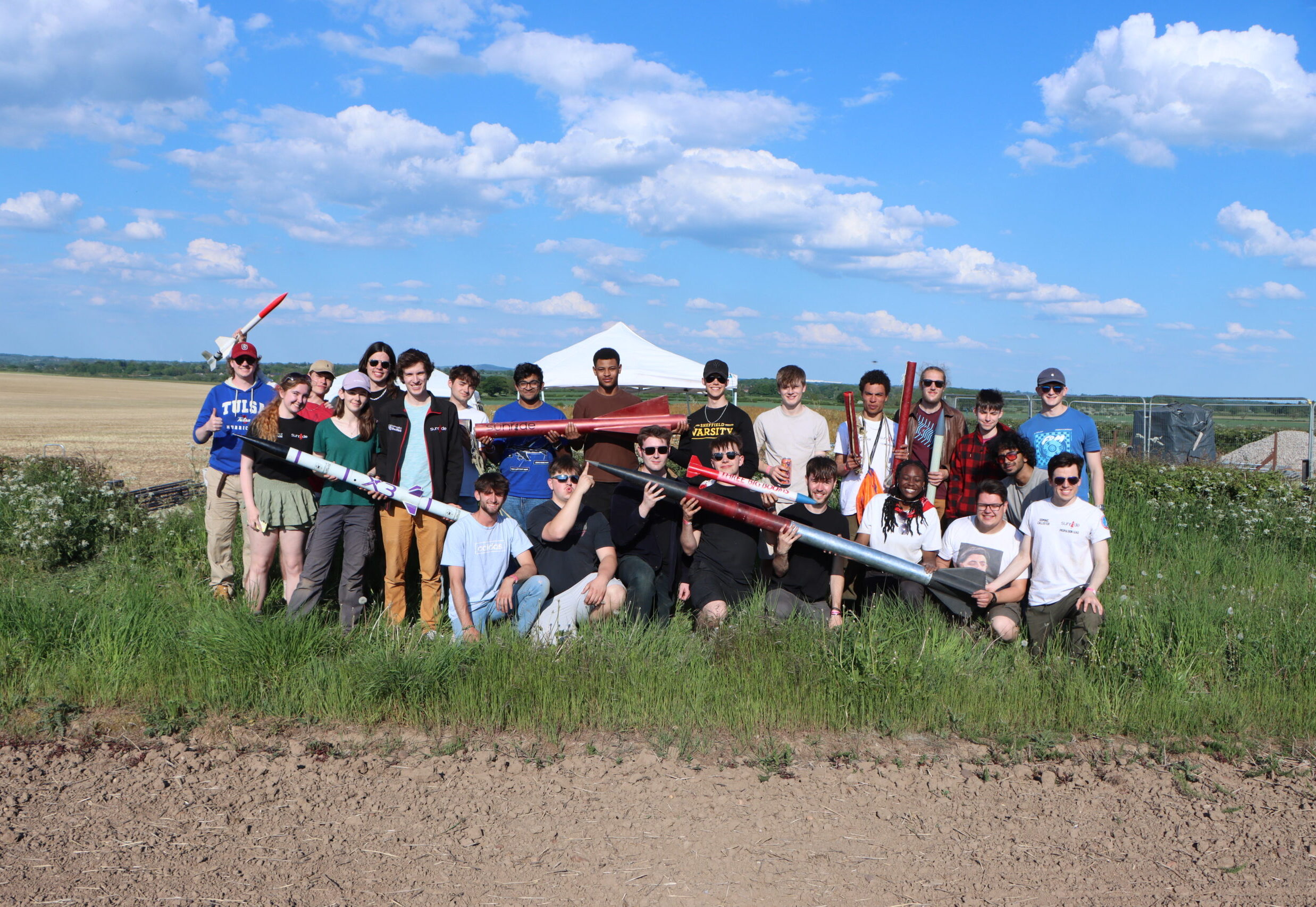 image of the Sunride rocketry team holding their rockets following a very successful launch day