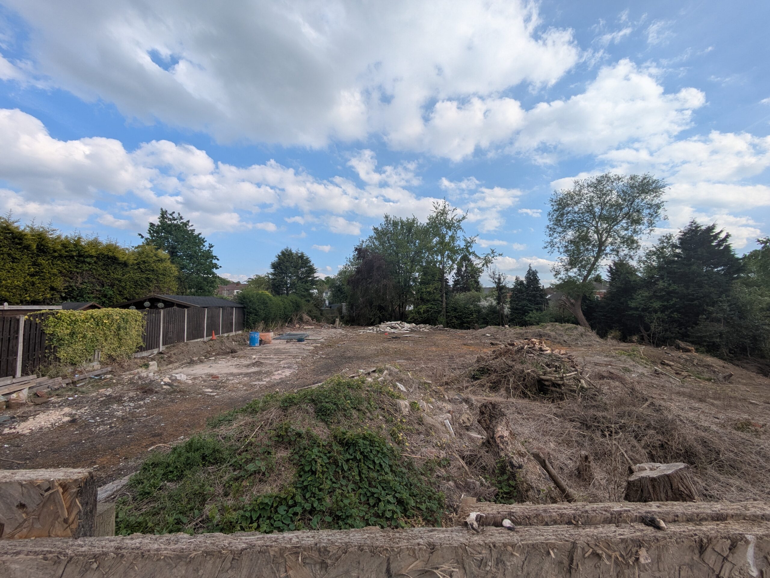 Land with lots of rubble and demolition and some trees.