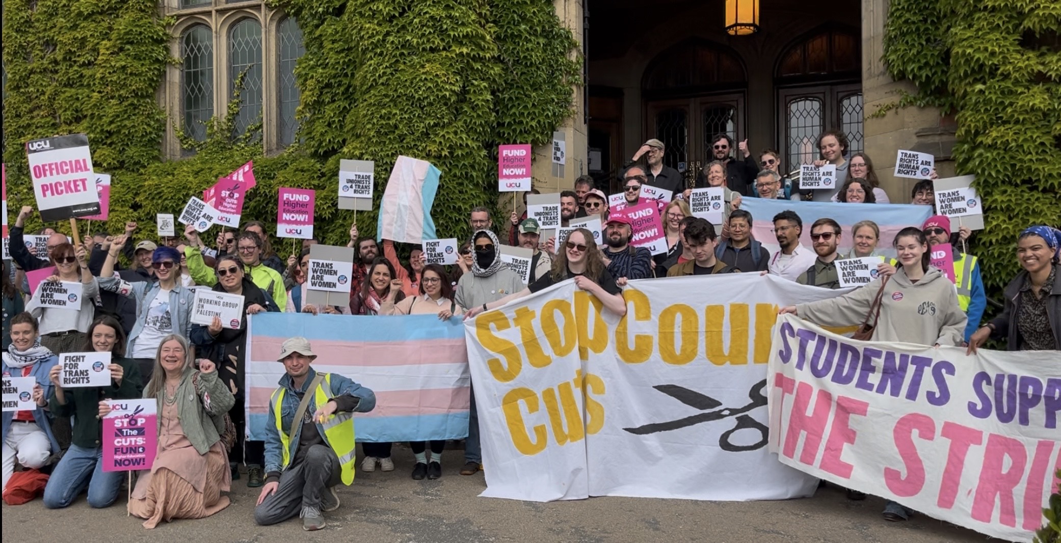 An image of protestors holding up banners and signs about job cuts and transgender rights
