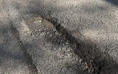 Potholes causing safety risk and damage to cars.