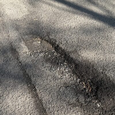Potholes causing safety risk and damage to cars.